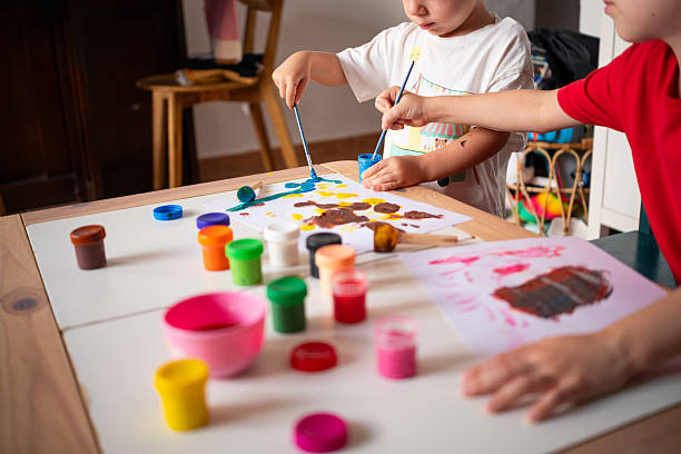 istock Children engaging in creative painting activity at home using colorful paints 2229534704