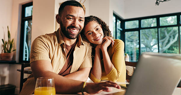 istock Happy, couple and planning on website, laptop or browsing for trip with tech, bonding and apartment. Online, booking and people with app for hotel reservation, woman and man with research in home 2229535052