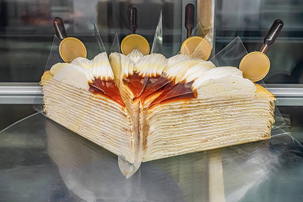 Layered dessert with cream and caramel topping, beautifully presented in a bakery display case