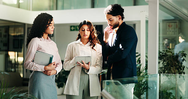 istock Business people, tablet and group in office, teamwork and conversation with budget report. Employees, collaboration and financial advisors in workplace, tech and digital app for email and feedback 2229535257