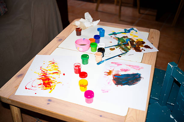 High angle view of students painting with water colors on art class at elementary school.