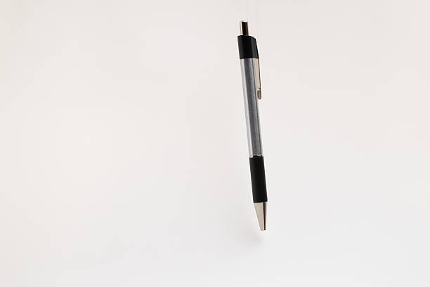 istock A sleek, black and silver pen stands upright on a clean white background, creating a minimalist and professional 2229535491