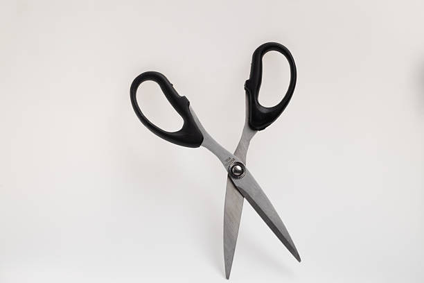 istock A pair of silver-bladed scissors with black handles is positioned open against a clean white background 2229536291