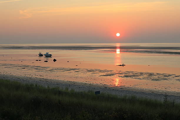 Stunning orange and pink skies from the sun setting over Cape Cod Bay