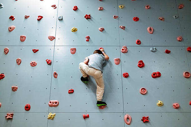 Boy climbing on bouldering wall
