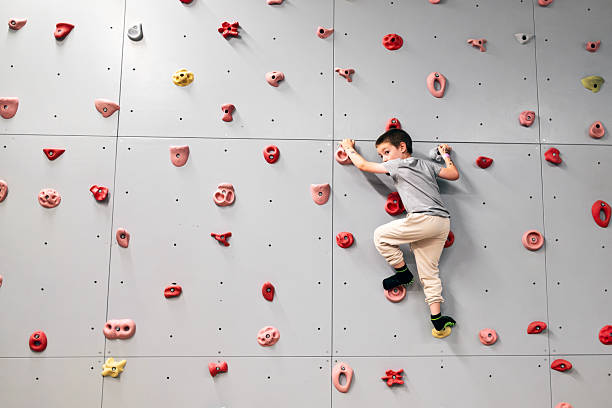 istock Child practicing rock climbing on colorful bouldering wall 2229537740