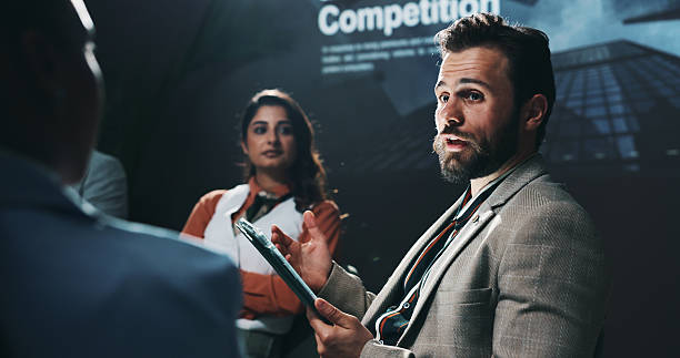 Tablet, panel and discussion with business people at summit for speaker, teamwork and conference. Collaboration, market competition and future of trading with employees on stage for seminar and event