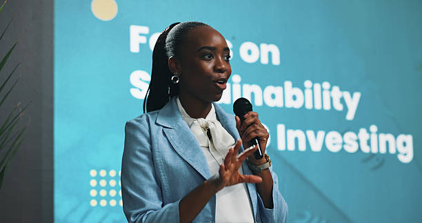 istock Black woman, presentation or seminar with mic for speech or environmental change at summit. Female person, employee or speaker with technology display for eco friendly investing or sustainability 2229538455