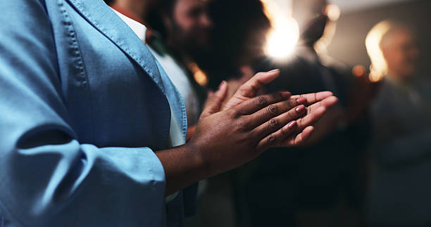 Diverse group of businesspeople applauding while sitting in the boardroom during a presentation