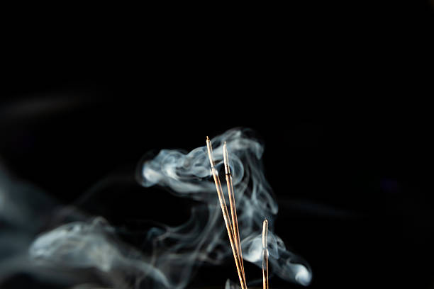 istock Three burning incense sticks with smoke on a black background. 2229538886