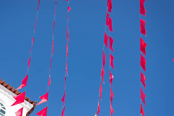 Plastic decorative objects. Red decorative flags hanging from the houses on a street. Ornaments.