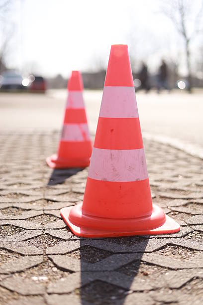 istock Two orange and white traffic cones are on the ground 2229540584