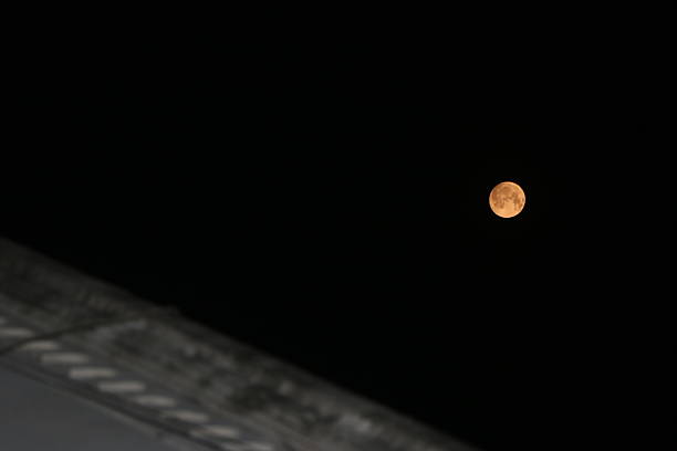 Super Moon In the night sky. March 19, 2011. A Super Moon is a new moon that passes much closer to the earth than usual, making it appear 30% larger than normal and brighter, often orange. Super Moons only happen about once every 18 years.