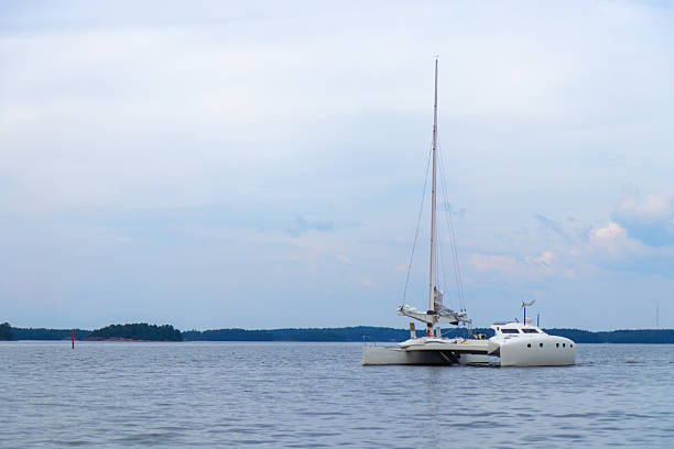 Modern catamaran sails smoothly over deep blue sea, under a clear sky. freedom, adventure, joy of exploring open waters on a perfect sailing day in a Baltic sea, Finland