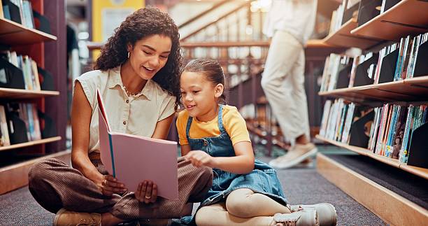istock Child, library or teacher reading book for support, development or storytelling in school. Learning, tutor or woman teaching with girl, smile or kid for literature lesson, fairy tale or education 2229544281