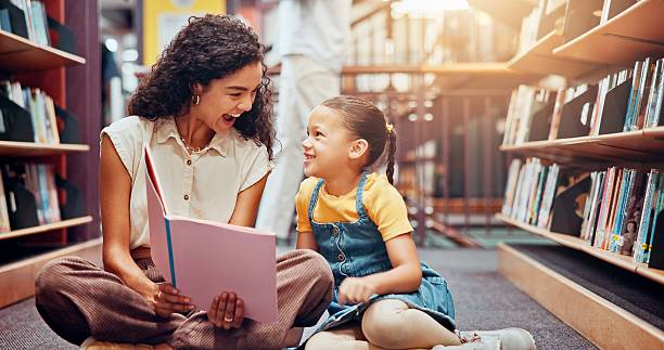 istock Child, excited or teacher reading book for learning, development or help in school. Teaching, happy or woman with girl, smile or kid in library for literature lesson, fairy tale or education support 2229544283
