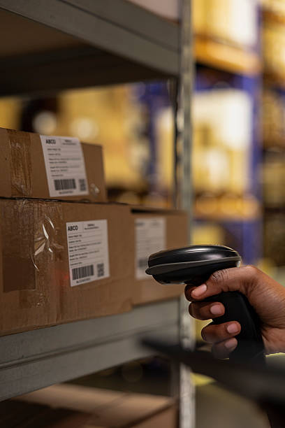 istock Close up of industrial worker scanning parcel details using tracking software 2229544787