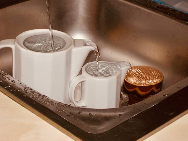 istock Kitchen teapots being filled incorrectly with water in a sink 2229548264