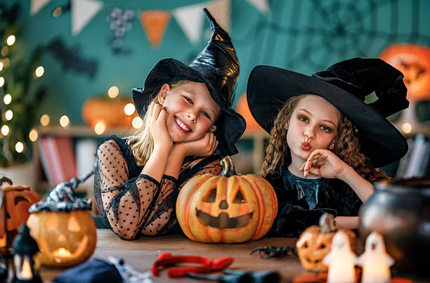 due ragazze stanno festeggiando halloween - kid halloween witch foto e immagini stock