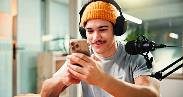 istock Creative, influencer and man with smartphone, podcast or reading comments on social media or online. Happy, podcaster and person with mobile app for reviews, content creation and followers on website 2229551717
