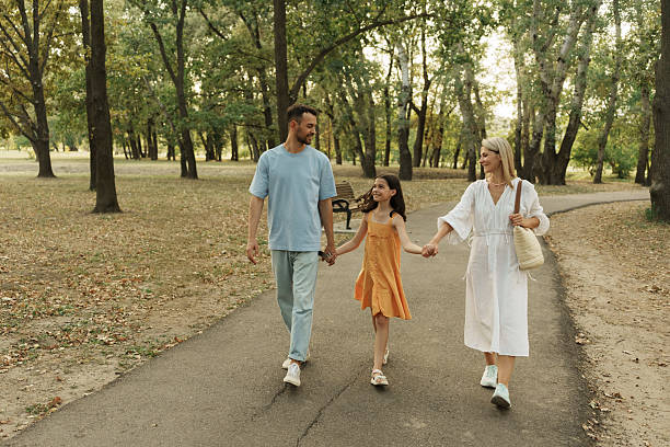 istock Happy family walking together in a peaceful park setting 2229553367