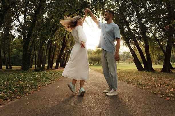 istock Couple dancing happily on a sunlit path surrounded by trees 2229553427