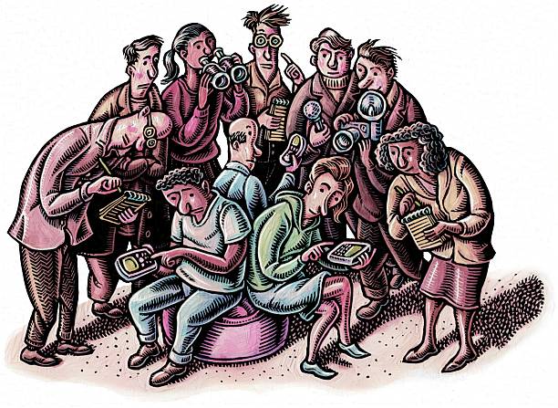 crowd of researchers watching a sitting couple use their electronic devices.
