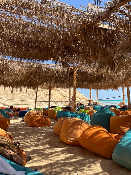 A shaded relaxation area on the beach at Orange Bay, Hurghada, Egypt, featuring comfortable cushions and a peaceful atmosphere. The photo captures the perfect spot to unwind, enjoy the sea breeze, and relax under the sun while overlooking the turquoise waters of the Red Sea.