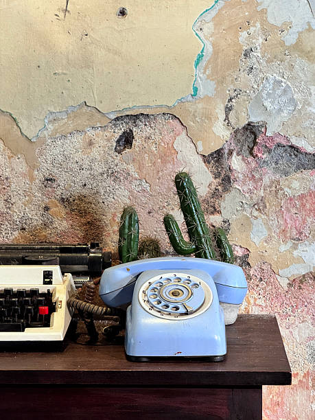 istock Vintage Typewriter and Rotary Phone Against Rustic Wall 2229556020