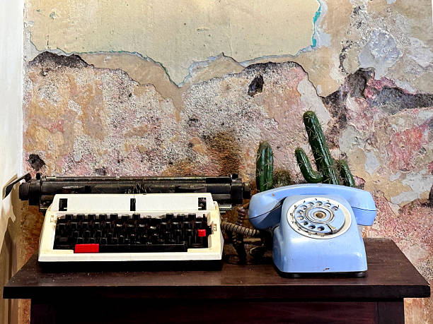 istock Vintage Typewriter and Rotary Phone Against Rustic Wall 2229556026