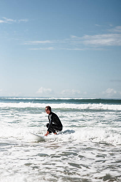 istock man trying to surf the waves 2229556171