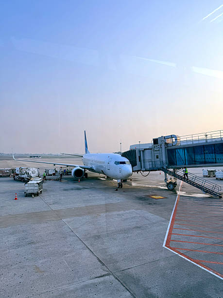 Jeddah, Saudi Arabia - April 29, 2024: Several planes await departure at Jeddah Airport, while ground vehicles transport passengers and cargo under a clear sky.