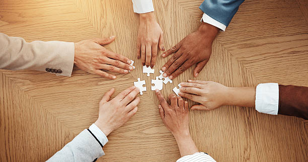 istock Hands, above and puzzle for team at office with solution, synergy and strategy for game at company. Group, jigsaw and problem solving with integration, challenge and collaboration at insurance agency 2229560767