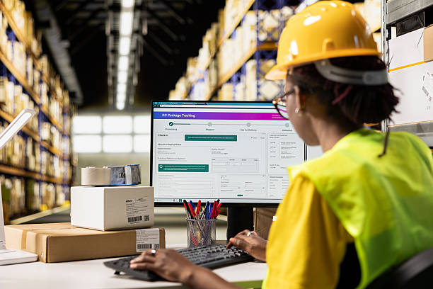 istock Black woman working in logistics center with tracking info on computer software 2229560838