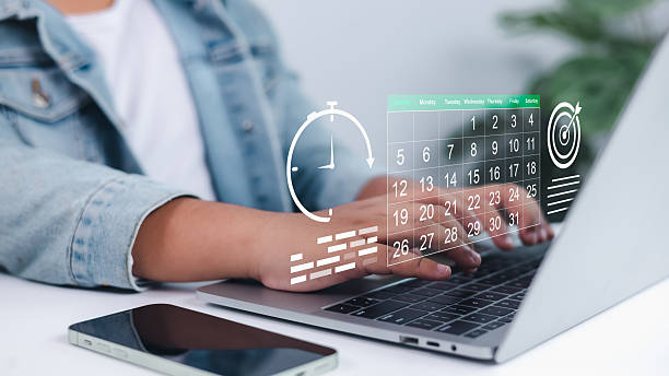 Person using laptop with digital calendar, clock, and target icons overlay, symbolizing effective time management, strategic planning, goal setting, and improving work efficiency and productivity.