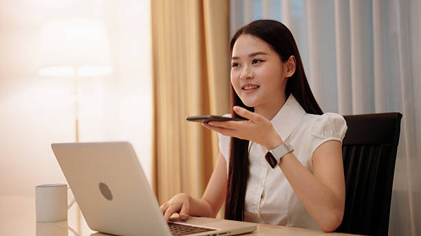 istock Asian woman getting work done at home with her laptop, using a voice assistant for support 2229565485