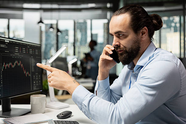 istock Stockbroker using phone to discuss with clients, executing buy and sell orders 2229566704