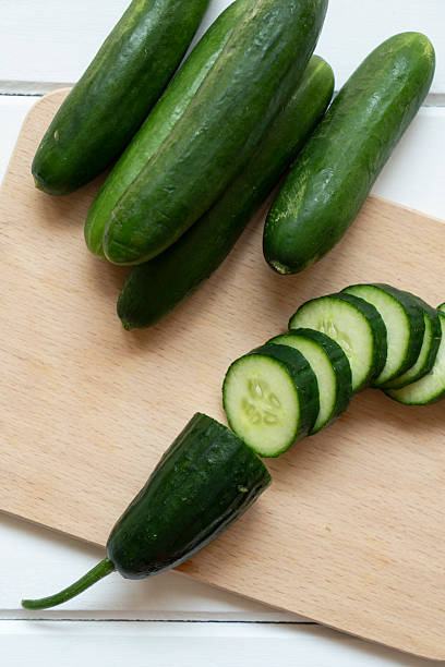 Fresh cucumber slices on a wooden cutting board