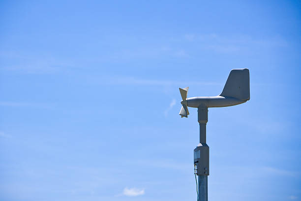 Blue sky and wind vane measuring wind speed and velocity