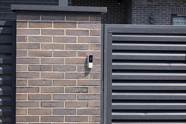 istock Modern intercom system mounted on a brick wall next to a slatted fence creates a welcoming home entrance during the day 2229568925