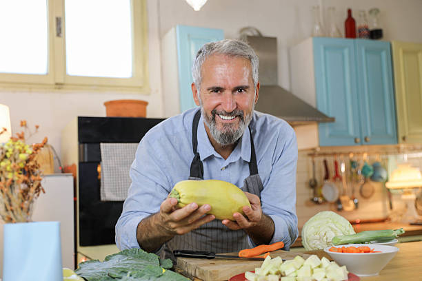 istock Older Man with Beard in Kitchen, Preparing Nutritious Meal with Fresh Vegetables 2229569543