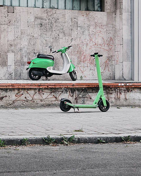 istock Different generations: two green scooters parked on the street. 2229570306