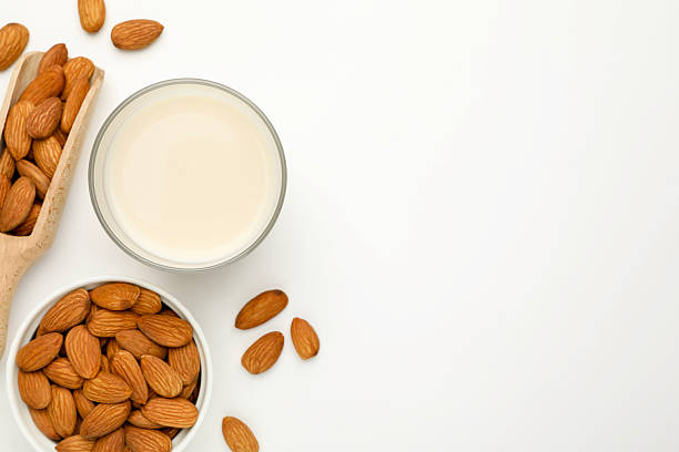 istock Fresh nut milk in glass and almonds on white table, flat lay. Space for text 2229577010