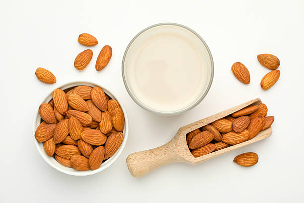 istock Fresh nut milk in glass and almonds on white table, flat lay 2229577018