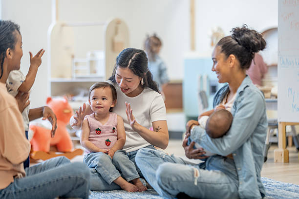 A group of expressive mothers and children sharing joyful moments in a nurturing gathering space, emphasizing connection, parenting, and early childhood experiences through interactive communal engagement, building supportive relationships.