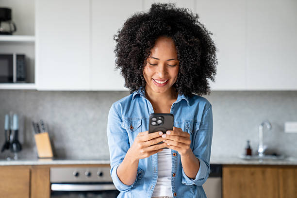 istock Happy woman at home texting on her cell phone and smiling 2229579783