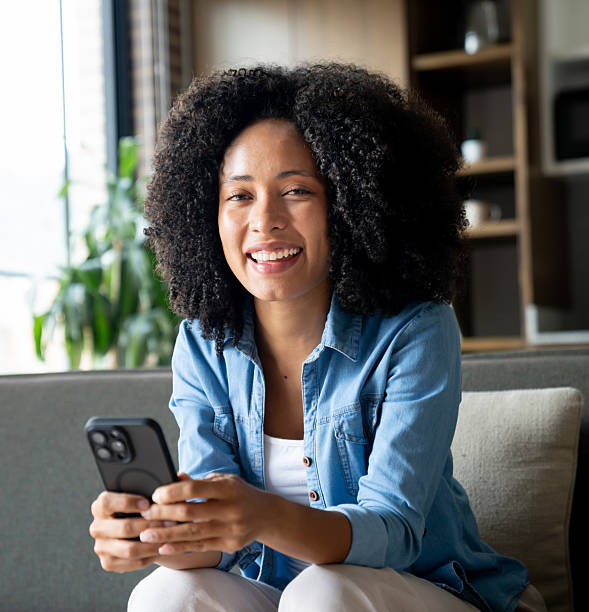istock Happy woman at home using her cell phone and smiling 2229579792