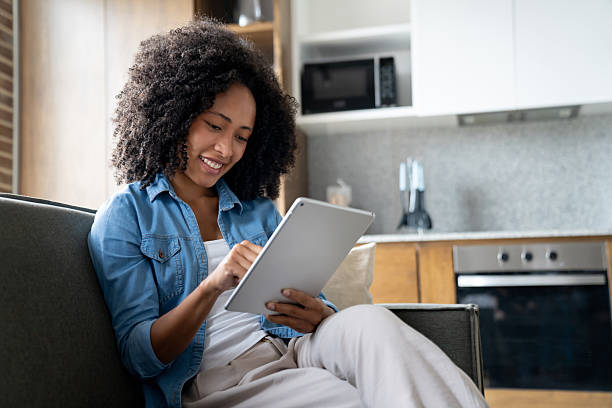 istock Woman at home using an app on a tablet and smiling 2229579835