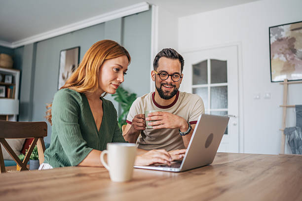 istock Young couple working from home on a laptop and drinking coffee 2229580503