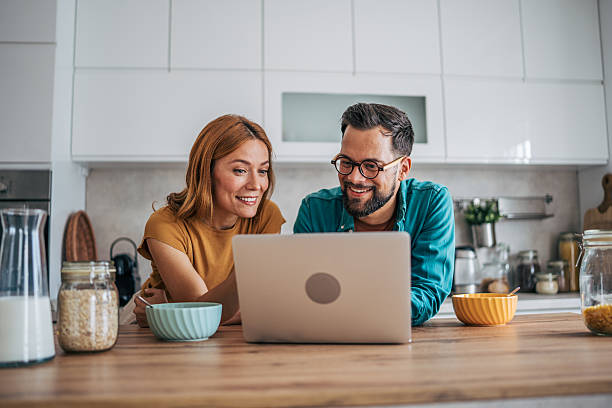 istock Happy couple enjoying breakfast and browsing internet on laptop 2229580649